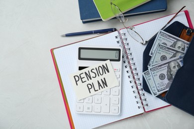 Photo of Card with phrase Pension Plan, dollar banknotes, calculator and notebooks on white office table, flat lay