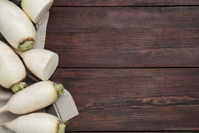 Photo of White turnips on wooden table, flat lay. Space for text