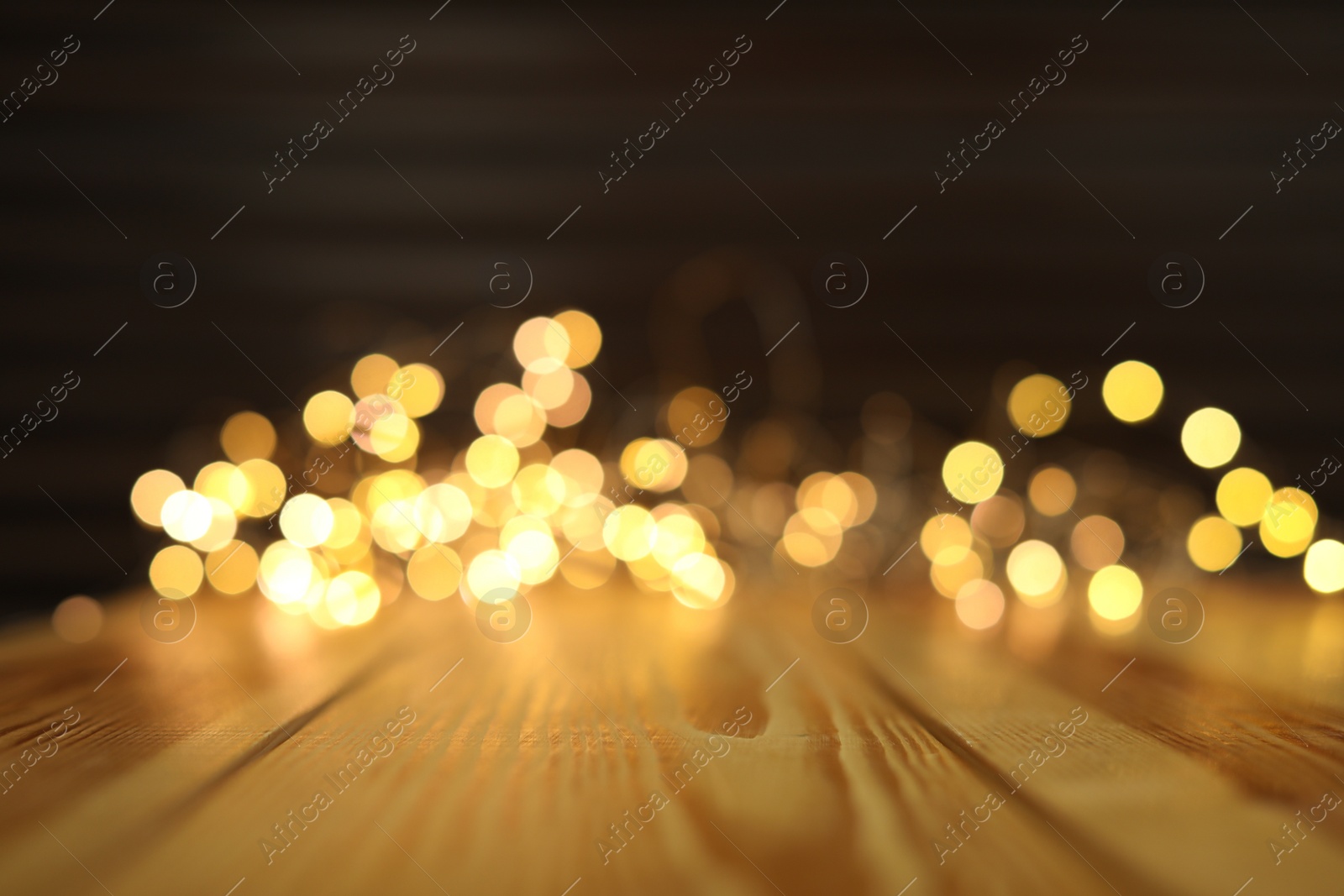 Photo of Empty wooden surface and blurred lights on background. Bokeh effect