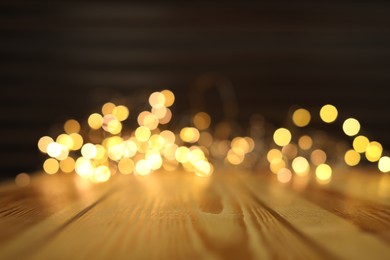 Photo of Empty wooden surface and blurred lights on background. Bokeh effect