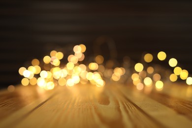 Empty wooden surface and blurred lights on background. Bokeh effect