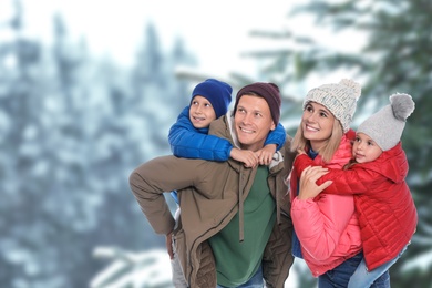 Happy family spending time together near winter forest