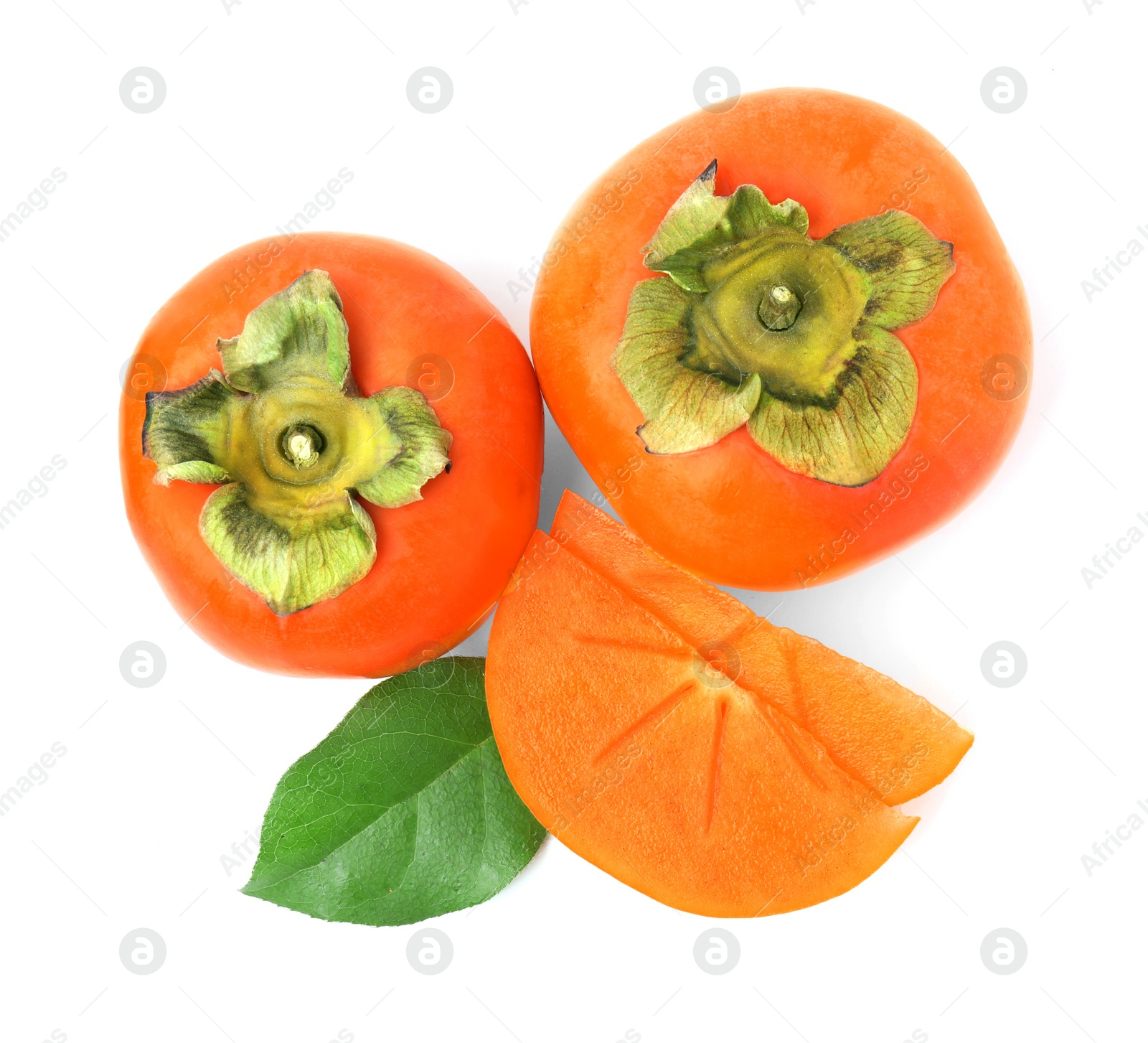 Photo of Whole and cut delicious ripe juicy persimmons with green leaf on white background, top view