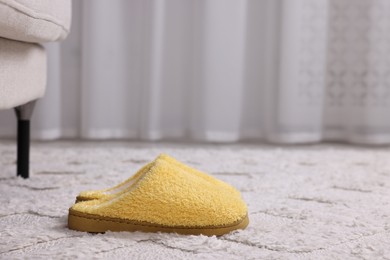 Photo of Yellow soft slippers on light carpet. Space for text