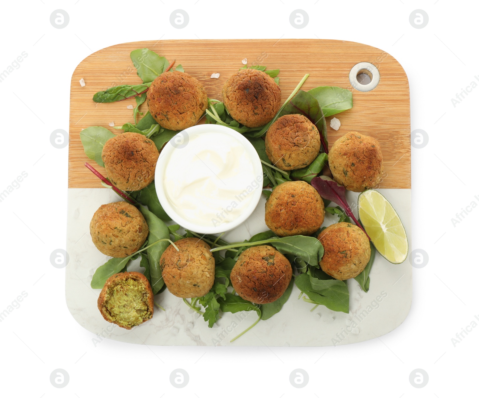 Photo of Delicious falafel balls with herbs, lime and sauce on white background, top view