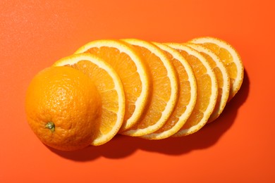 Slices of juicy orange on terracotta background, top view