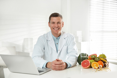Photo of Nutritionist with laptop at desk in office