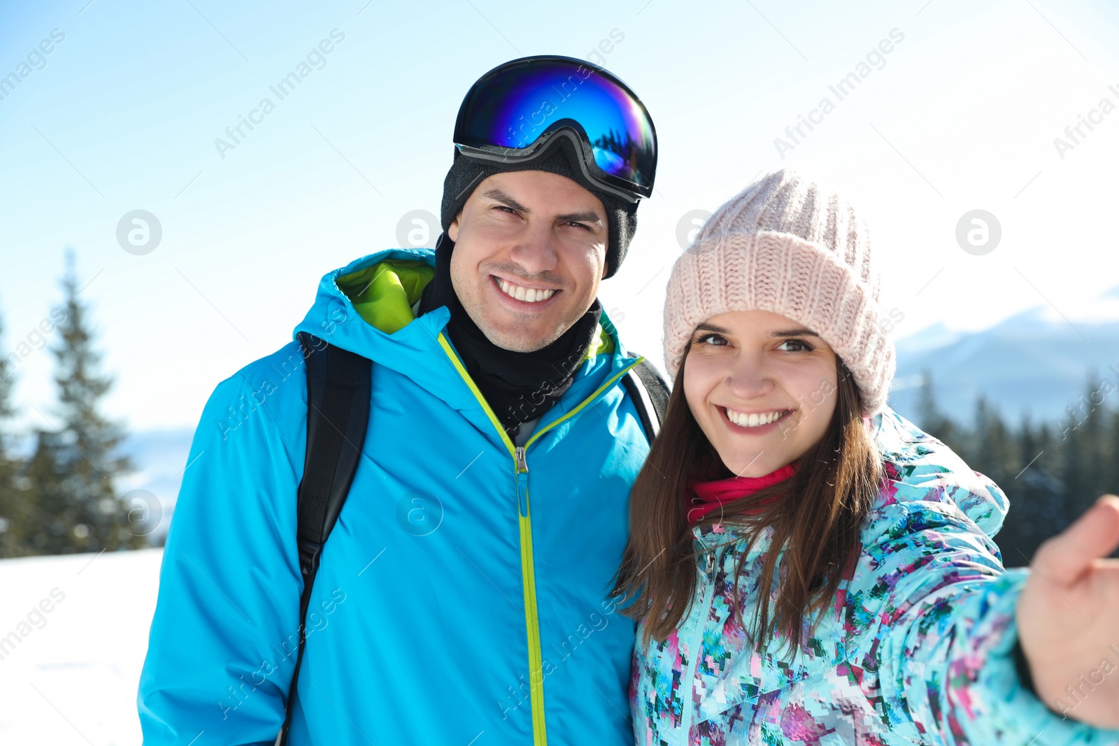 Photo of Happy couple taking selfie in mountains. Winter vacation