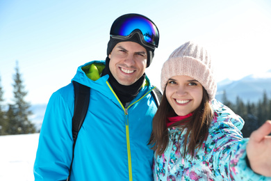 Happy couple taking selfie in mountains. Winter vacation