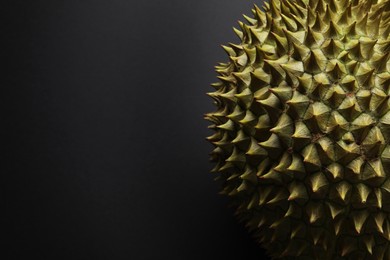 Fresh ripe durian on black background, closeup. Space for text