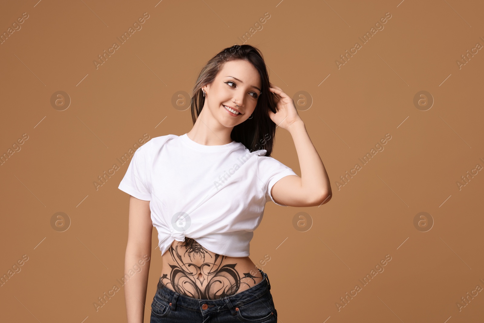 Photo of Portrait of smiling tattooed woman on beige background