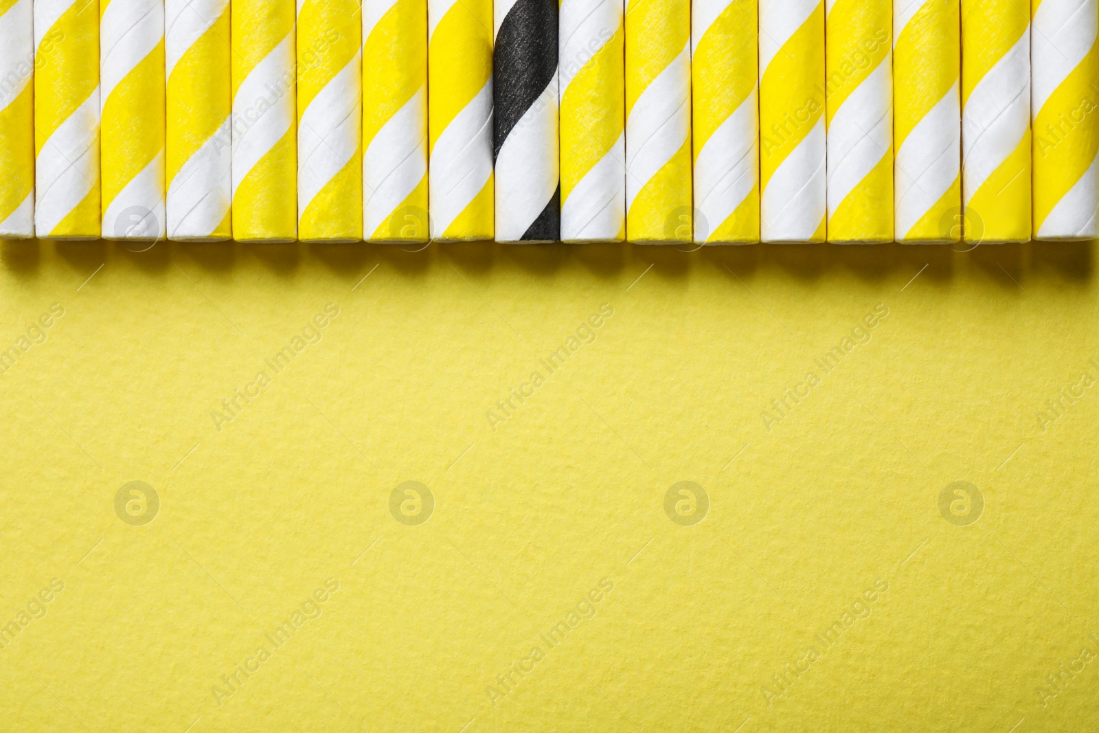 Photo of Collection of straws and different one on yellow background, flat lay. Space for text