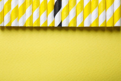 Collection of straws and different one on yellow background, flat lay. Space for text