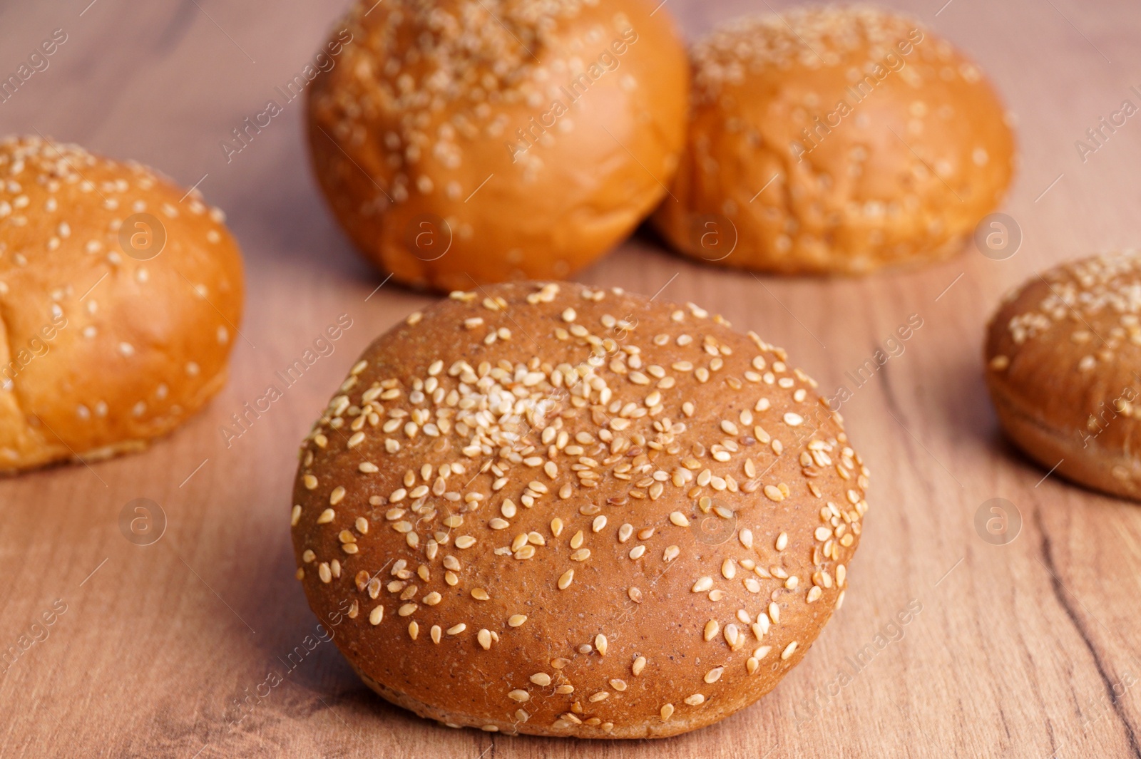 Photo of Fresh buns with sesame seeds on wooden table