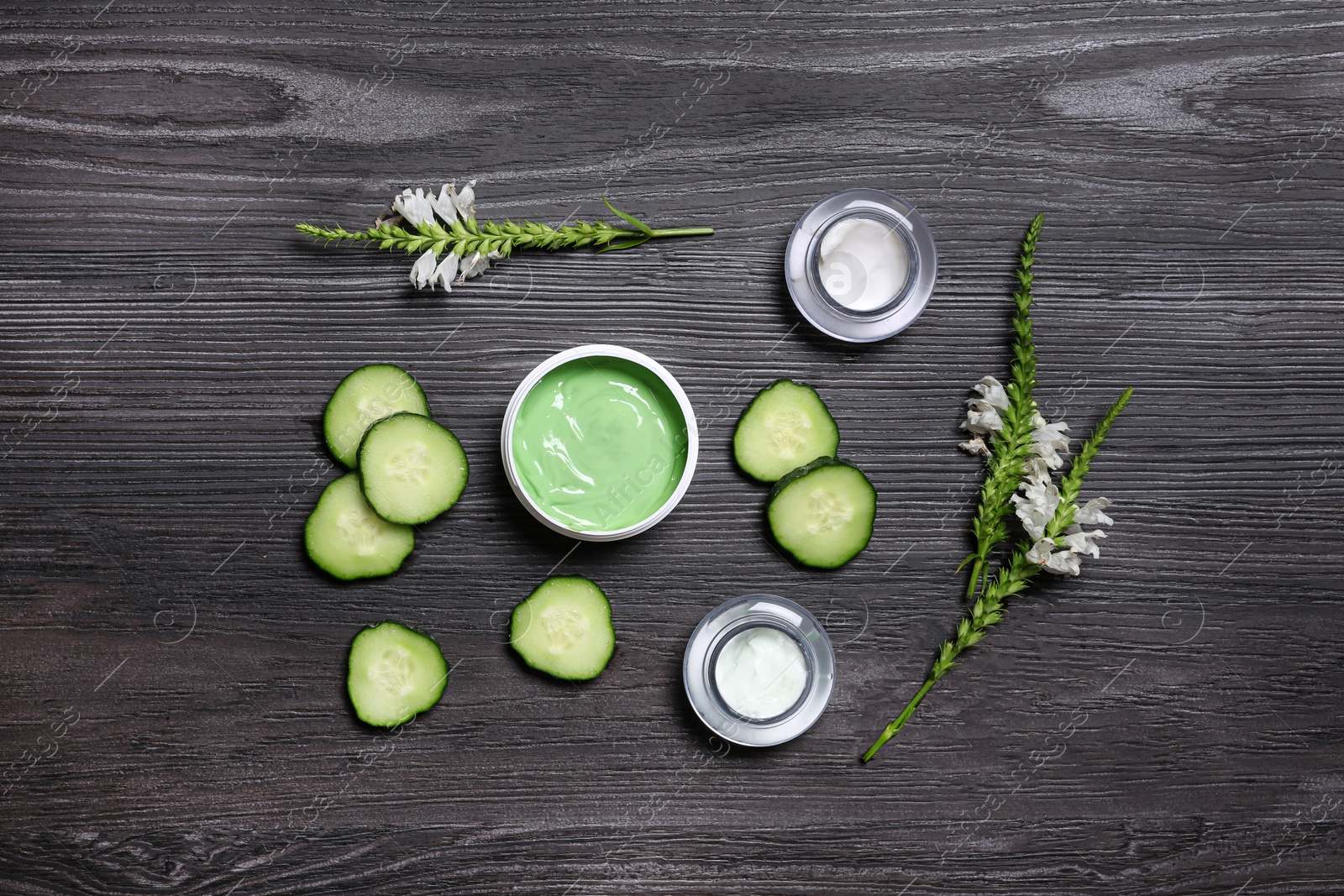 Photo of Flat lay composition with jars of body cream on dark wooden background