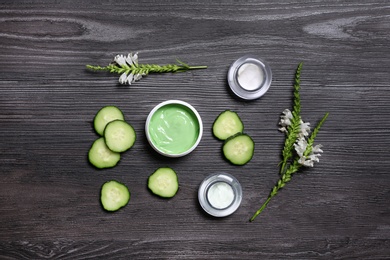 Flat lay composition with jars of body cream on dark wooden background