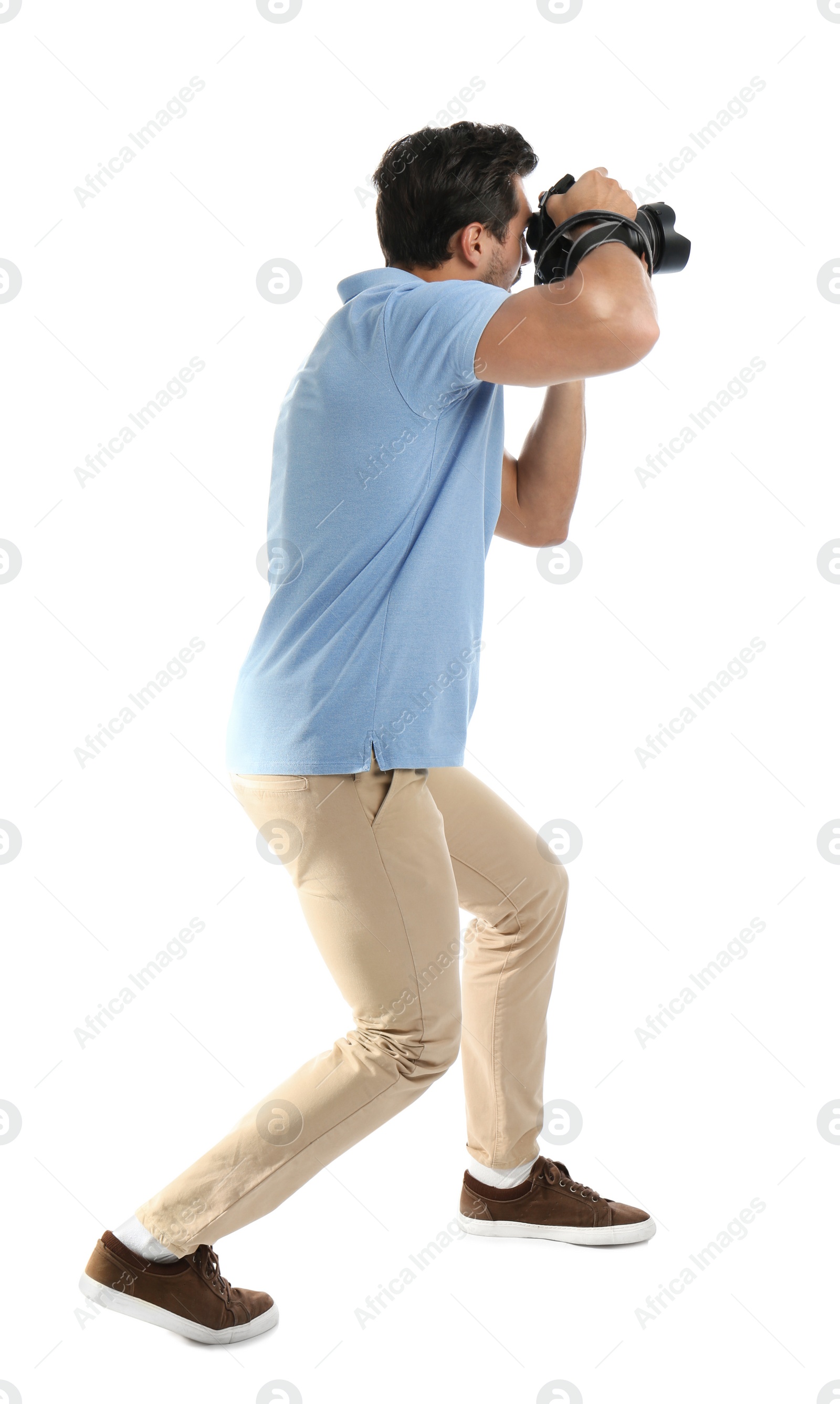 Photo of Young professional photographer taking picture on white background