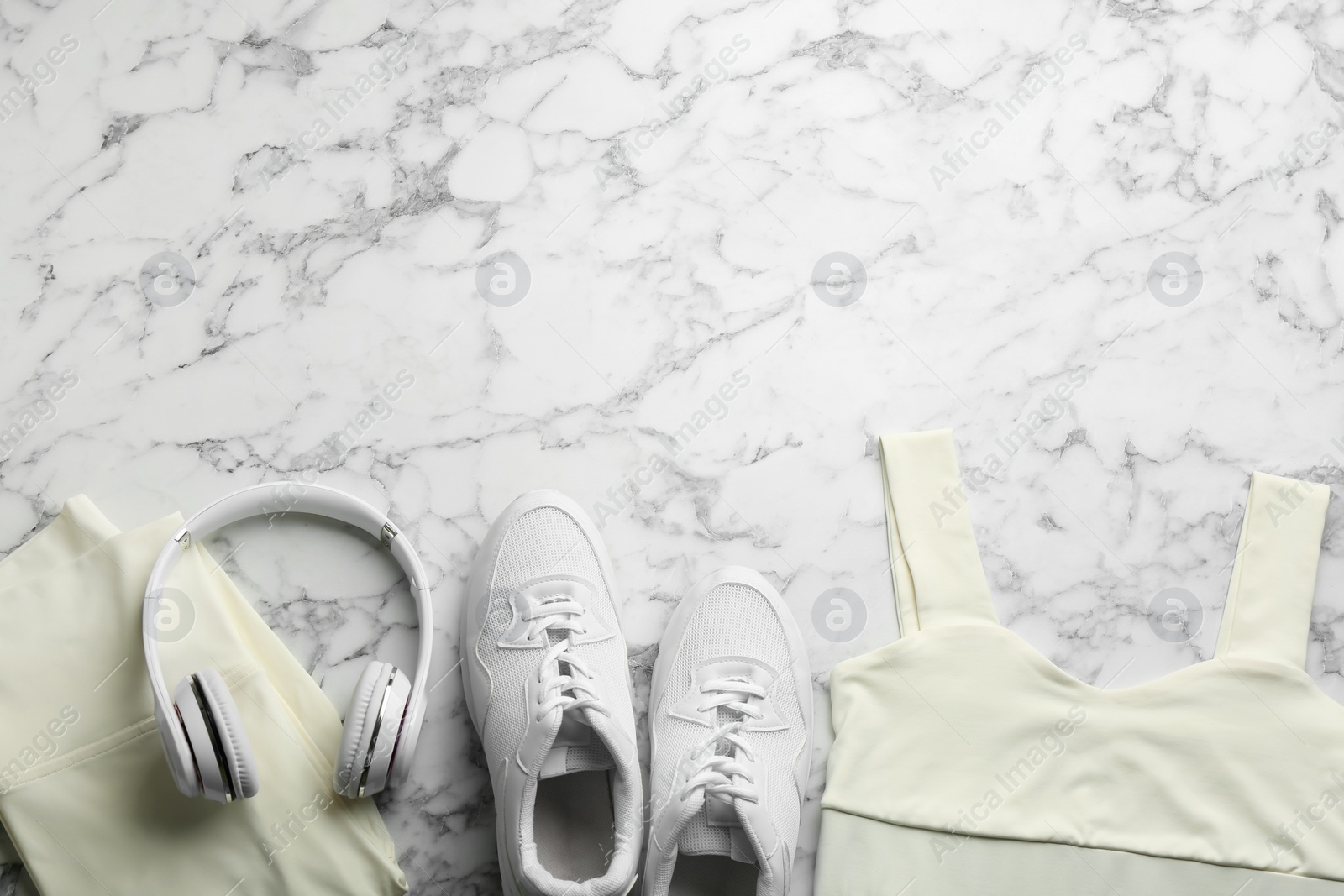 Photo of Flat lay composition with sportswear and equipment on white marble table, space for text. Gym workout