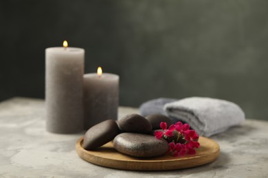 Photo of Spa stones and red flowers on grey table