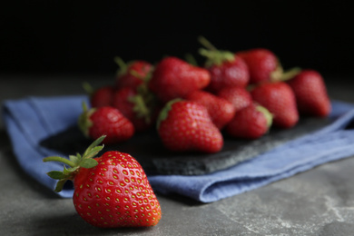 Photo of Many delicious ripe strawberries on grey table