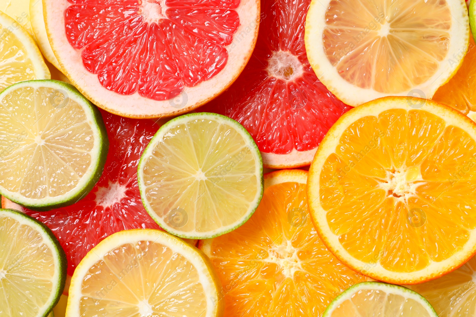 Photo of Different sliced citrus fruits as background, top view