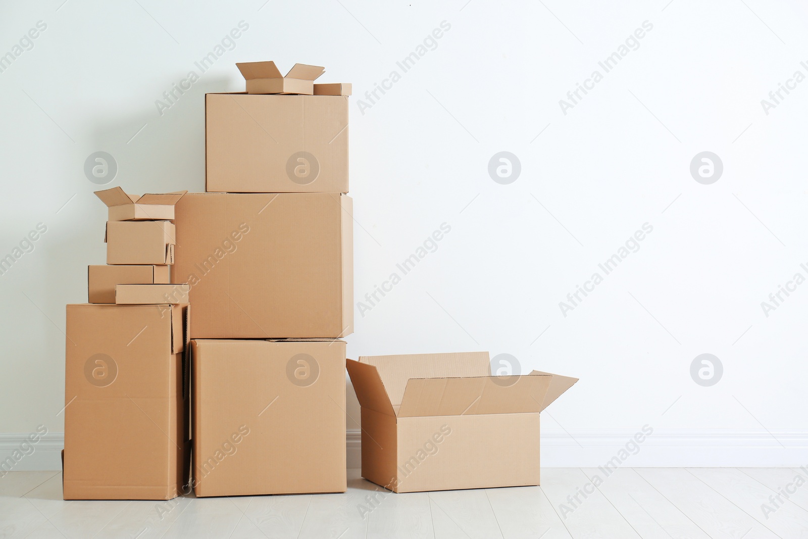 Photo of Cardboard boxes on floor near white wall