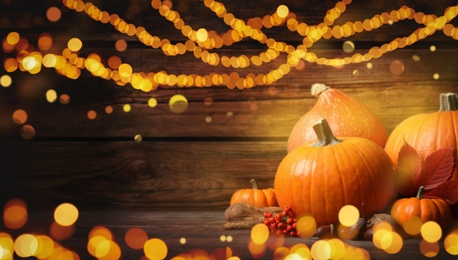 Composition with ripe pumpkins on wooden table, bokeh effect. Happy Thanksgiving day, banner design 