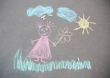 Child's chalk drawing of girl on asphalt, top view