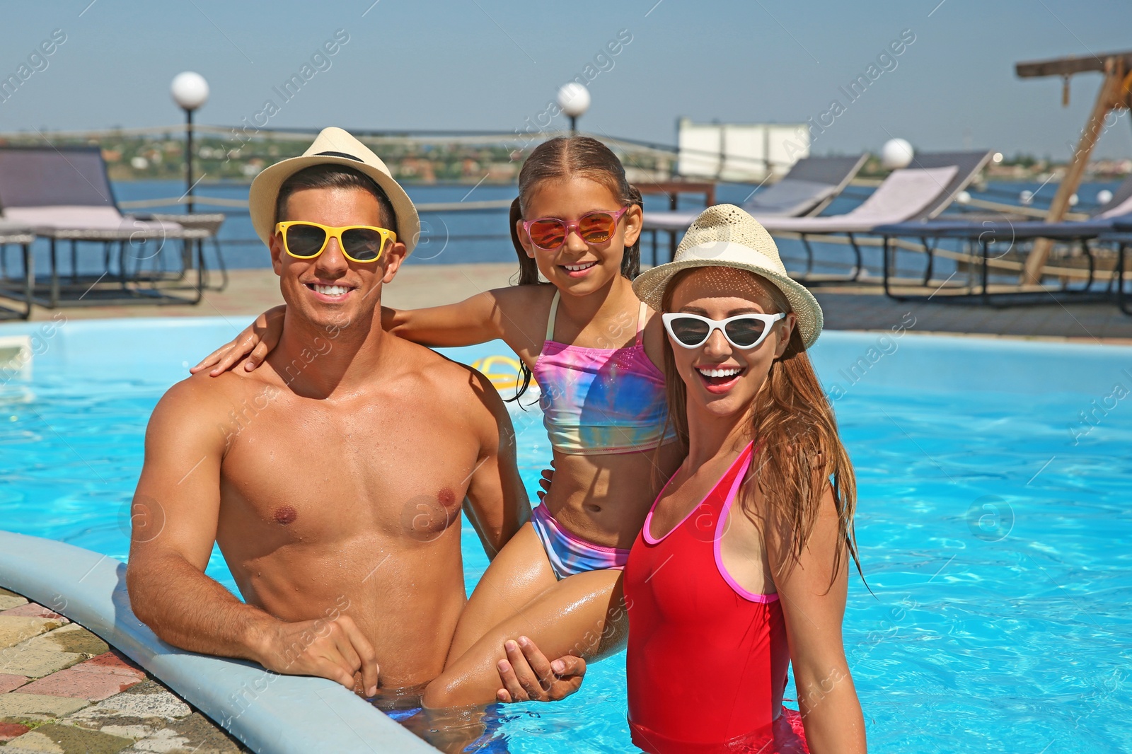 Photo of Happy family in swimming pool on sunny day