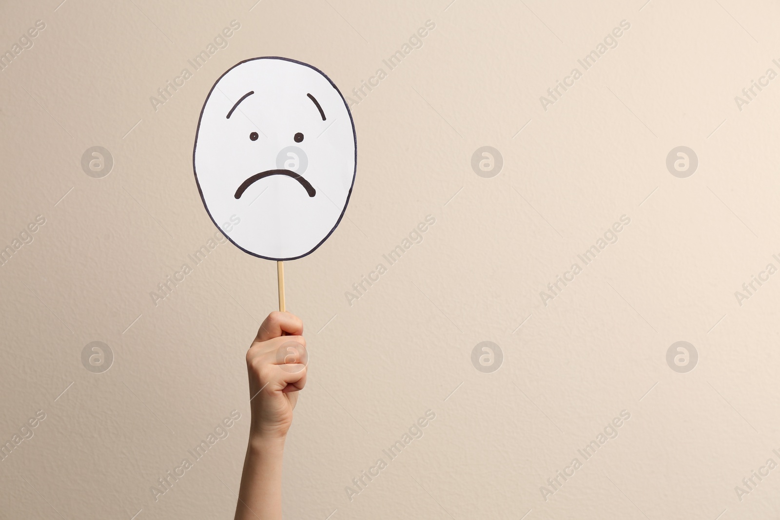 Photo of Woman with sad paper face on beige background, closeup. Space for text