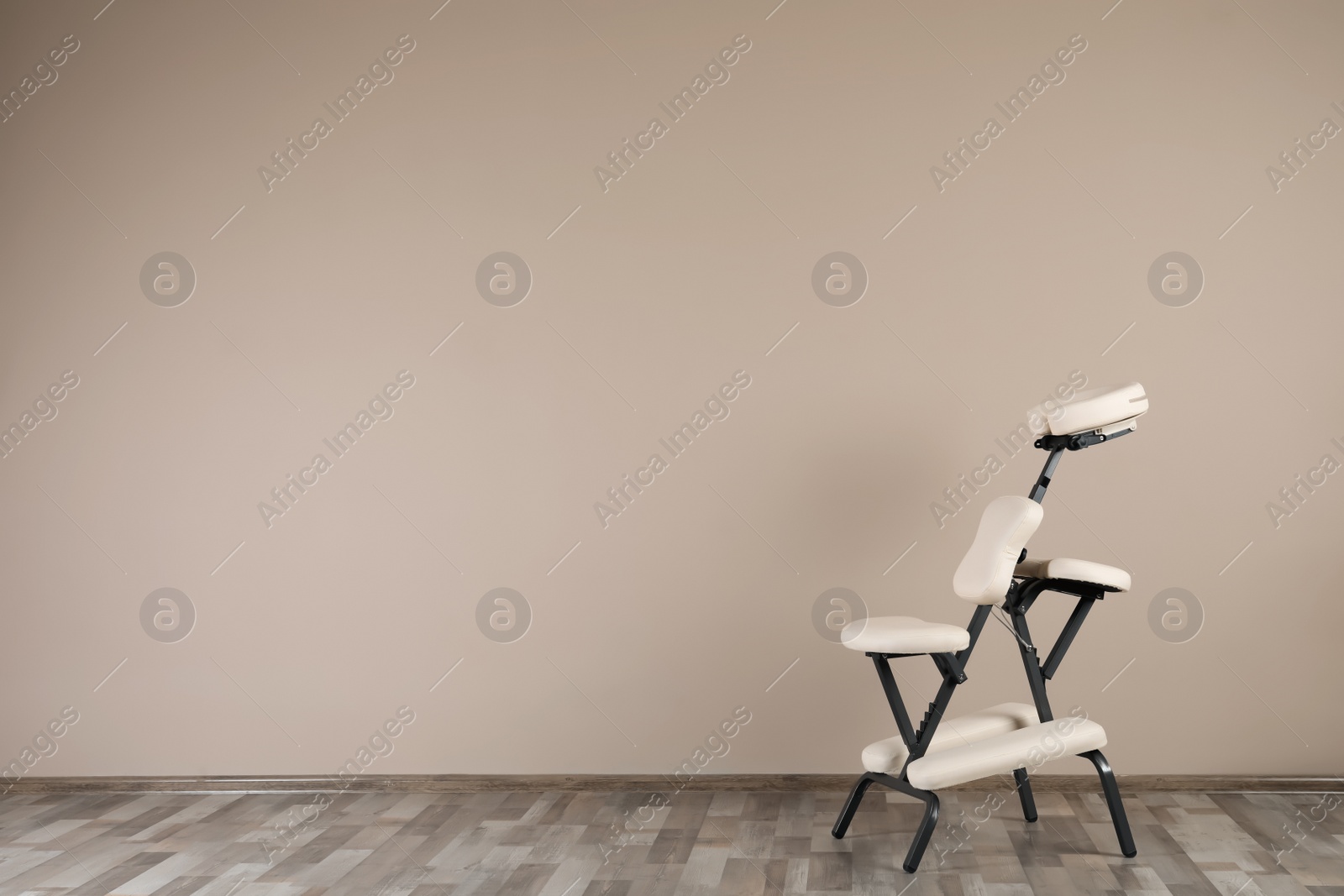 Photo of Modern massage chair near beige wall indoors, space for text. Medical equipment