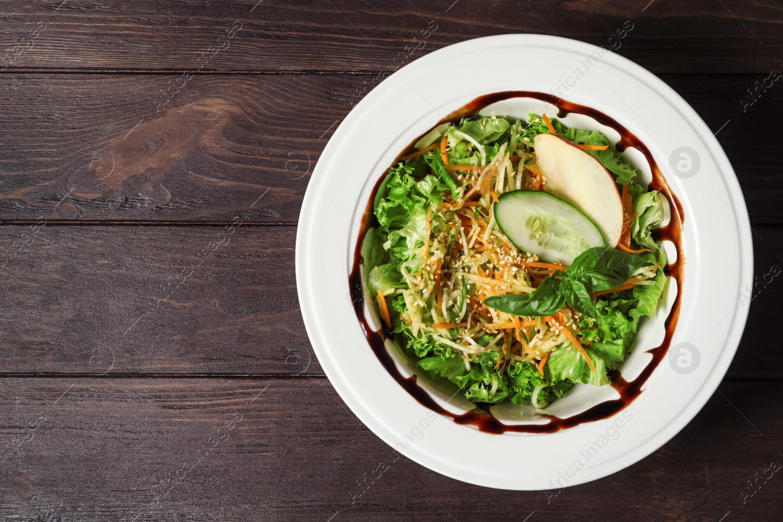 Photo of Plate with delicious fresh salad on table, top view