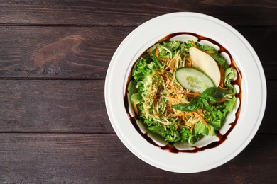 Photo of Plate with delicious fresh salad on table, top view