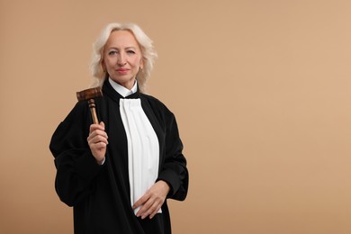 Photo of Senior judge with gavel on light brown background. Space for text