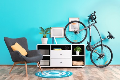 Stylish room interior with bicycle and armchair