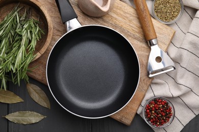 Photo of Frying pan and spices on grey wooden table, flat lay