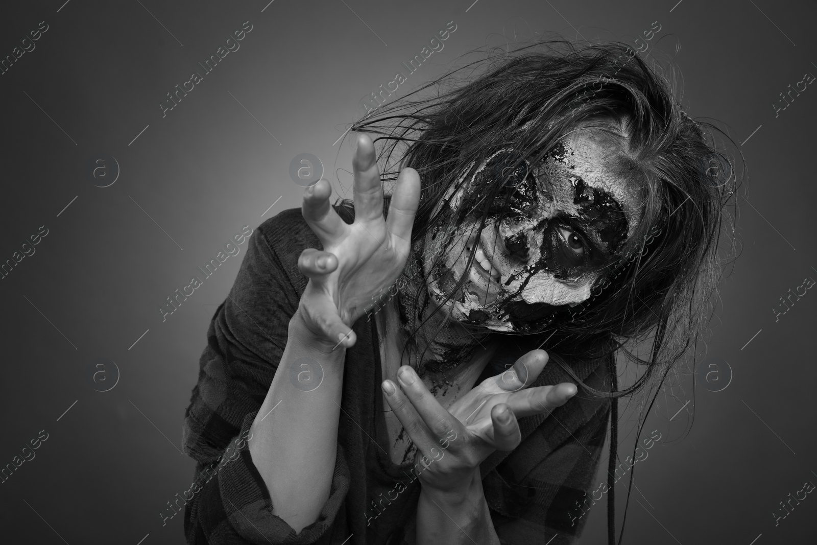 Photo of Scary zombie on dark background, black and white effect. Halloween monster