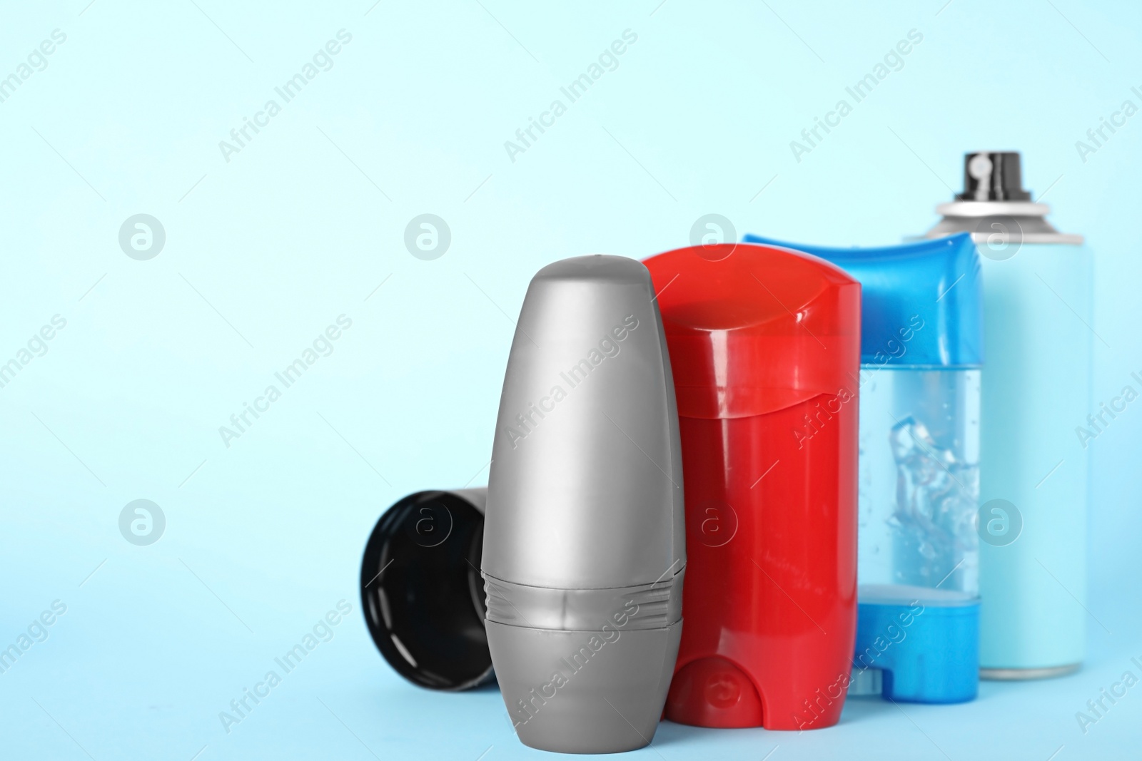 Photo of Set of different male deodorants on light blue background