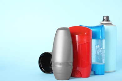 Photo of Set of different male deodorants on light blue background