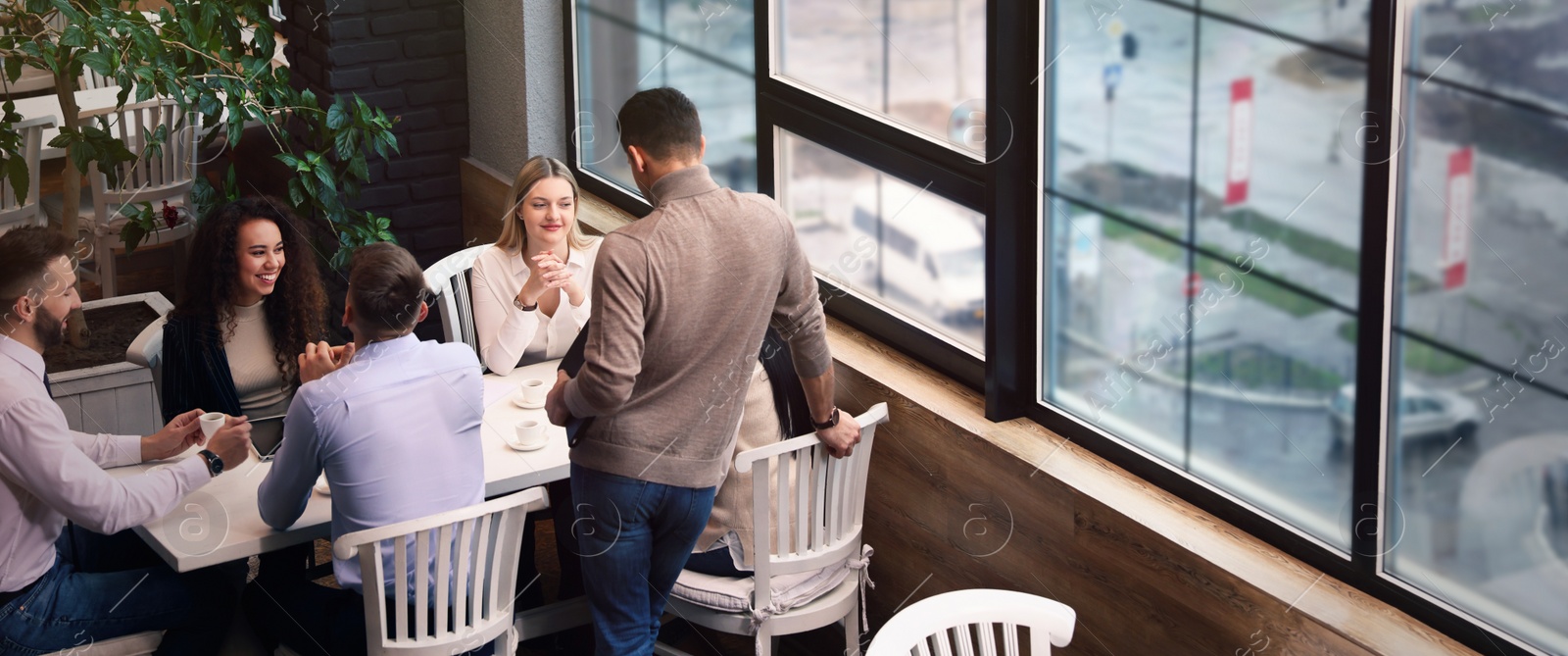 Image of Group of coworkers having coffee break in cafe. Banner design