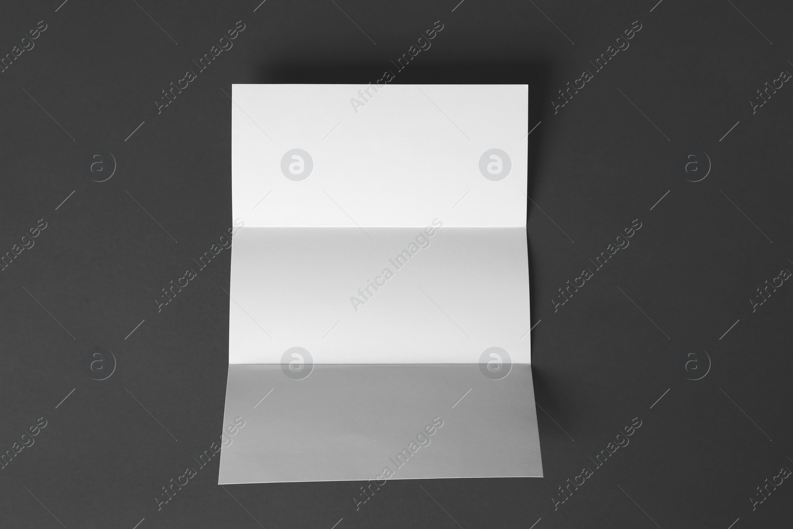 Photo of Blank brochure on dark grey background, top view. Mock up for design