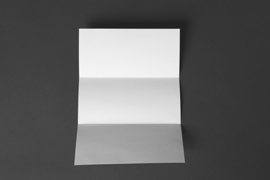 Photo of Blank brochure on dark grey background, top view. Mock up for design