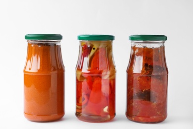 Jars with tasty pickled food on white background