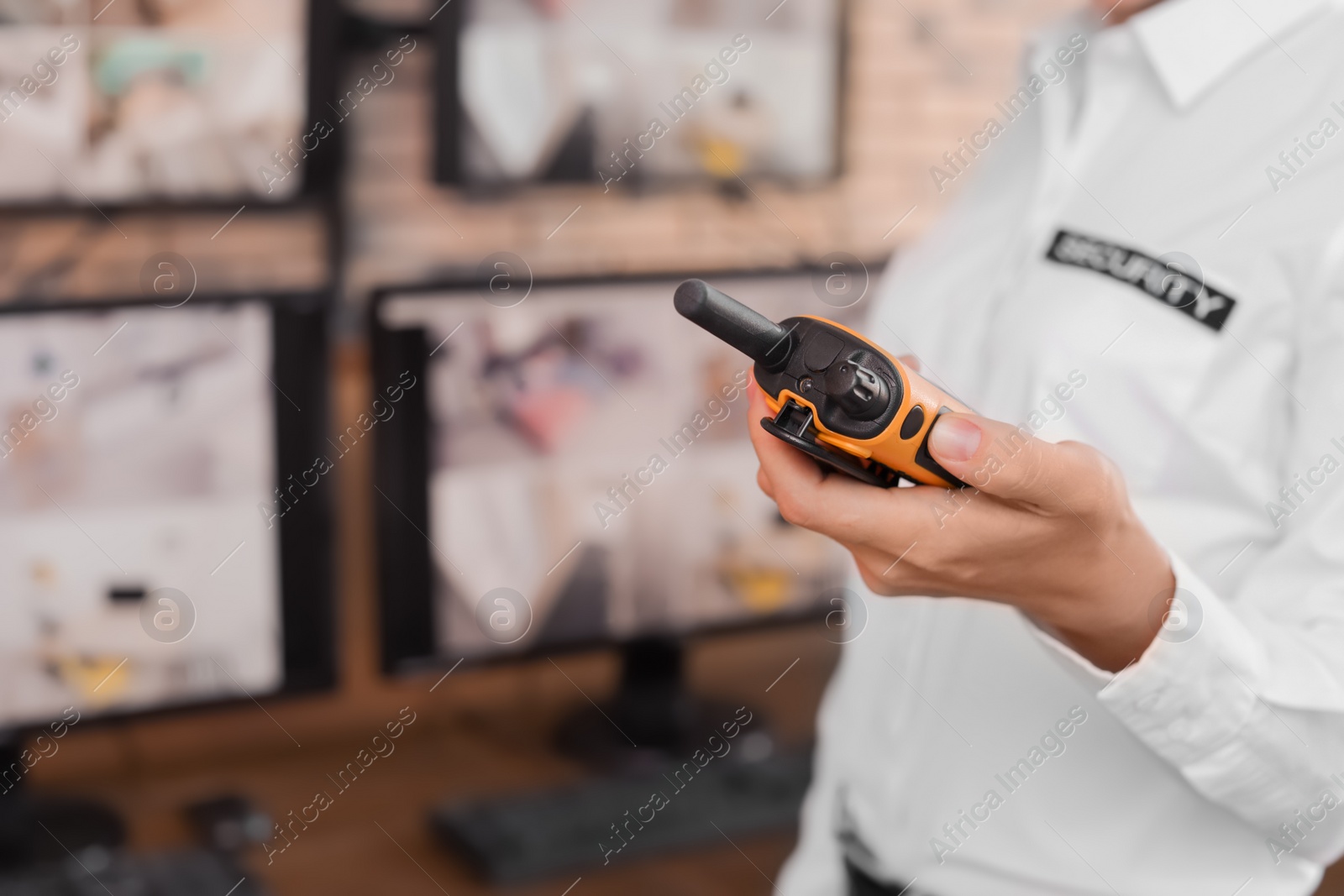 Photo of Female security guard with portable transmitter at workplace, closeup. CCTV surveillance