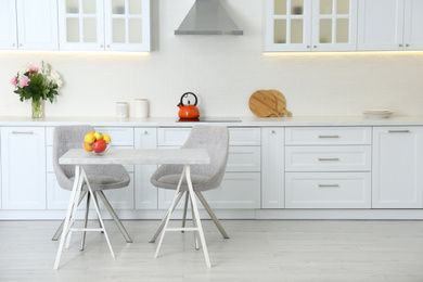 Photo of Table with chairs in modern kitchen interior