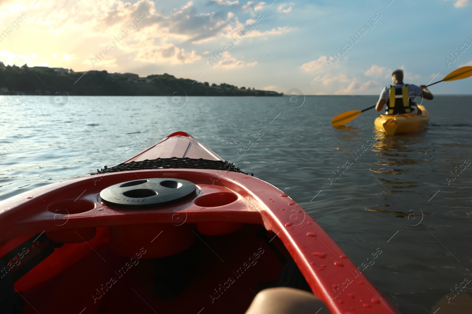 Photo of Man in life jacket kayaking on river, view from other boat. Summer activity