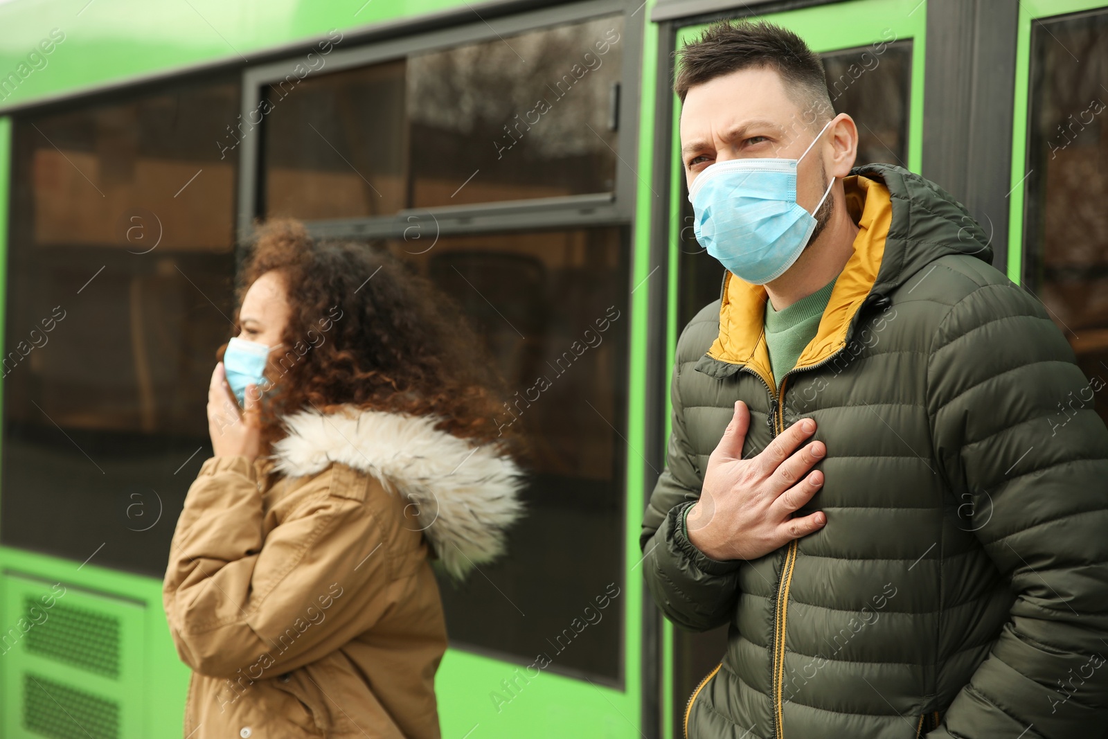 Photo of People with disposable masks near bus outdoors. Virus protection