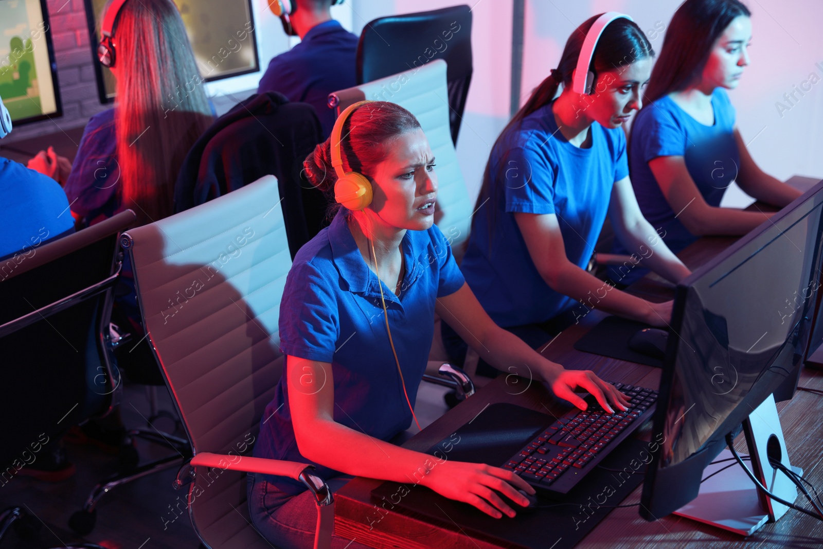 Photo of Young people playing video games on computers indoors. Esports tournament