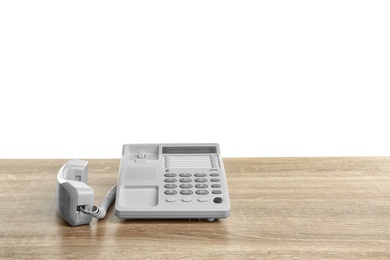 Telephone off hook on table against white background