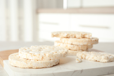 Photo of Puffed rice cakes on board indoors, closeup. Space for text